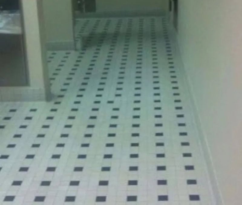 Empty hallway with black and white checkered tile floor and open doorways.