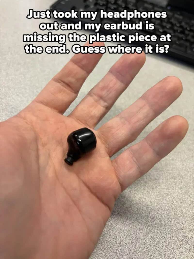 A hand holding a small black plastic piece, with text about missing an earbud.