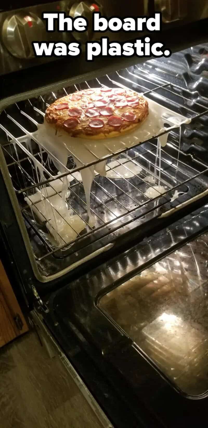 Pizza on a baking sheet inside an oven with the caption 'The board was plastic.'.