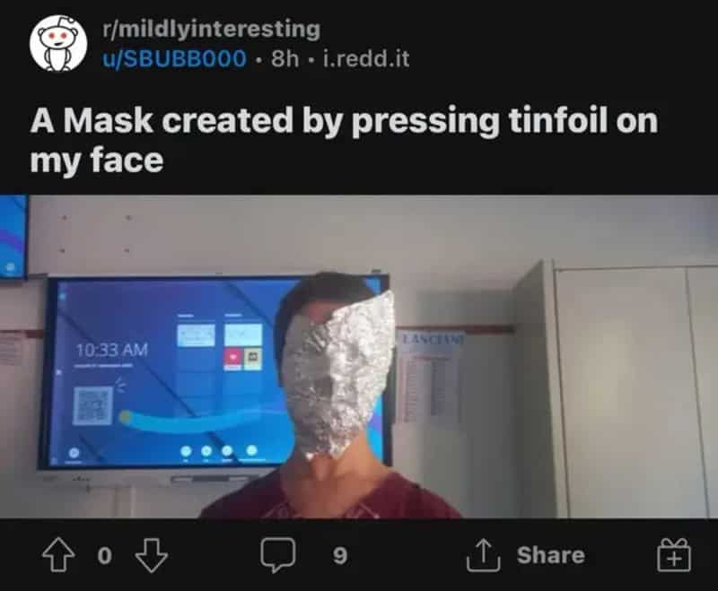 Person with face covered in foil, screen in background, caption about mask made with tinfoil.