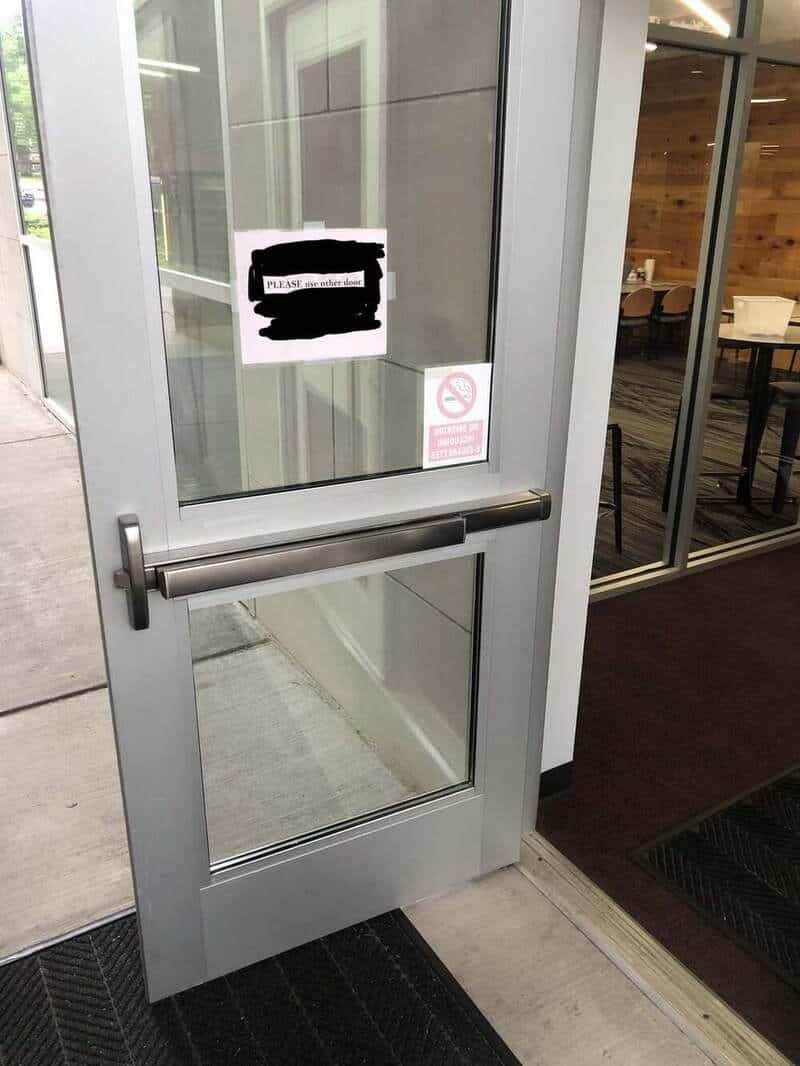 Glass door with a sign and no smoking notice, leading into a building.