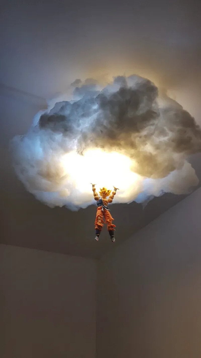 A small toy figure hanging from a cloud-shaped light fixture on the ceiling.