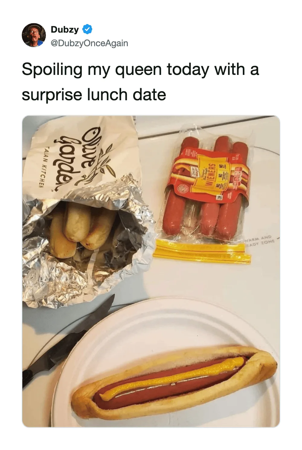 Hot dog with mustard and ketchup on a paper plate, snacks, and a surprise lunch bag.