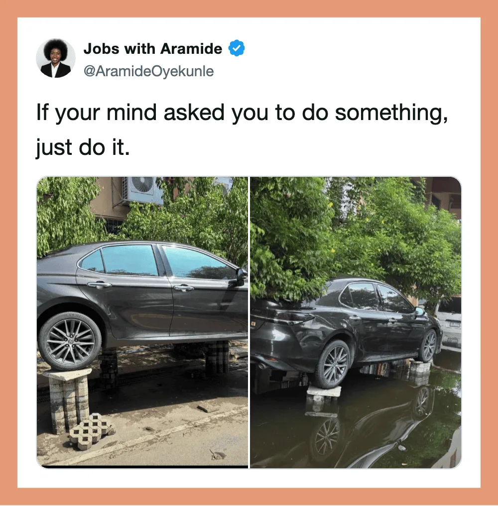 Two cars are parked on makeshift supports, one on bricks and the other on blocks, with water beneath.