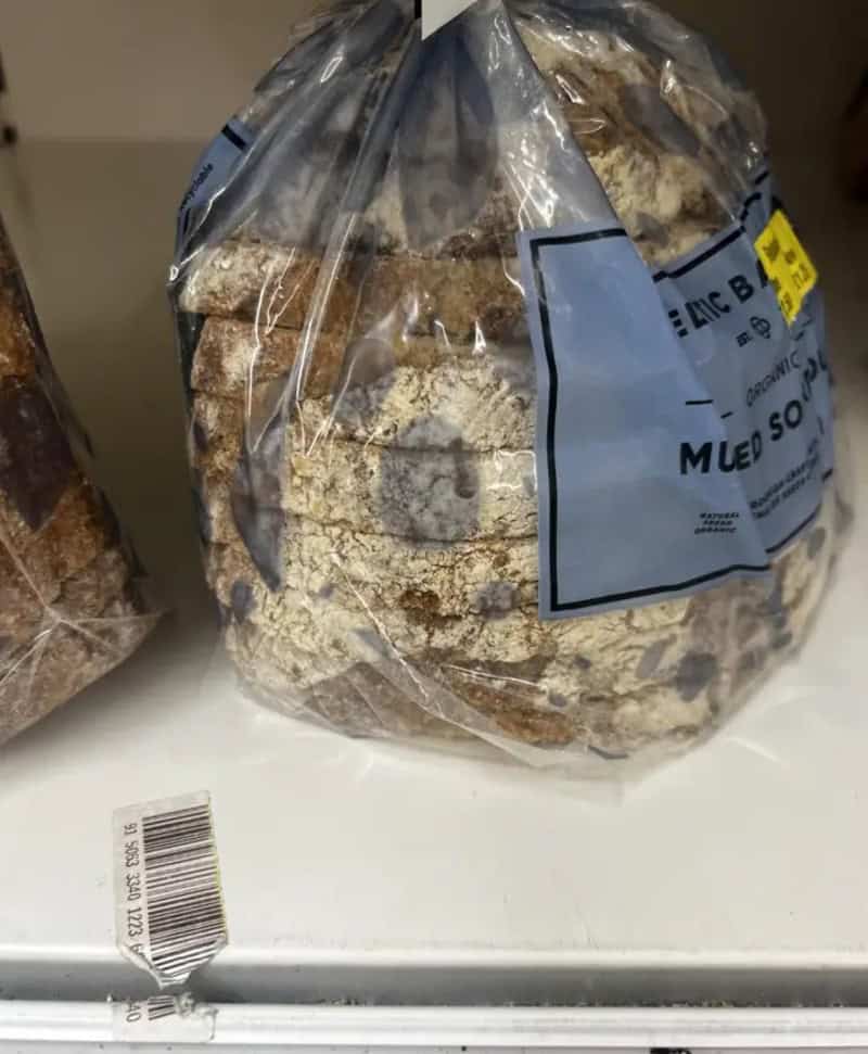 Bread in a plastic bag with a label, on a white surface.