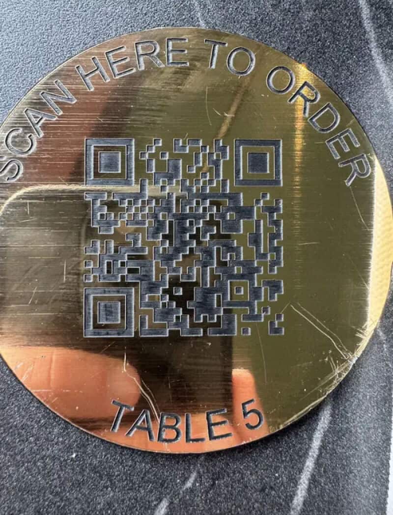 Scan here to order, Table 5, gold circular sign with QR code.