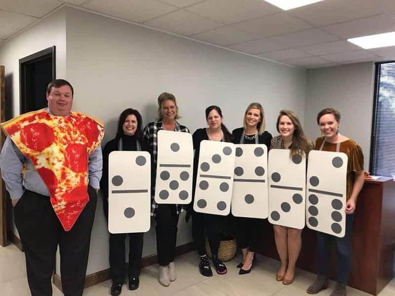 Group of six people dressed as dominoes and a pizza slice in an office.