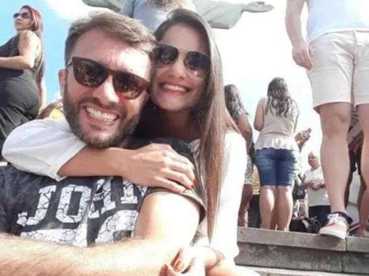Couple taking a selfie with Christ the Redeemer in the background at Christ the Redeemer statue in a.