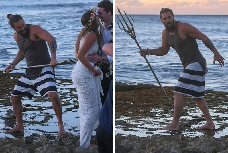 Man with trident photobombing wedding photo at the beach.