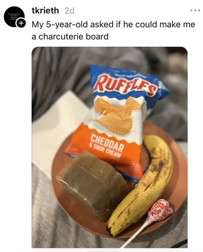 Charcuterie board with Ruffles Cheddar chips, banana, lollipop, and a small block of cheese.