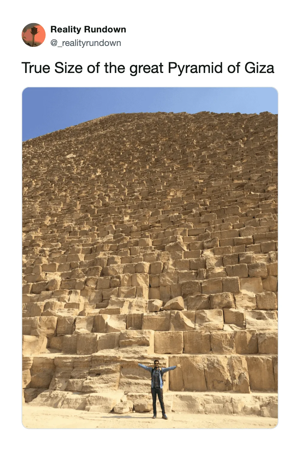 Person standing in front of the Great Pyramid of Giza showing its massive size.