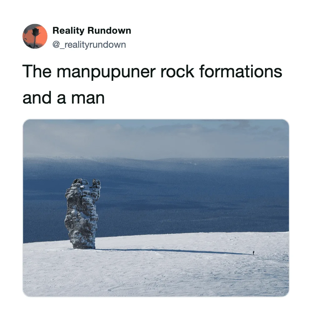 The manpupuner rock formations in a snowy landscape with a person for scale.