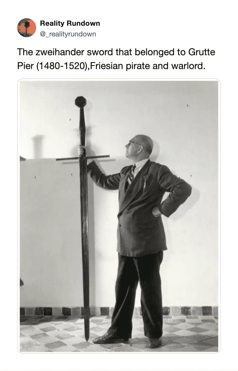 Man in suit with Zweihander sword at Grutte Pier museum.