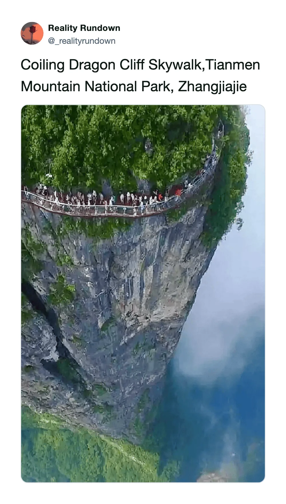People walking on a narrow bridge on a steep cliff at Tianmen Mountain National Park.