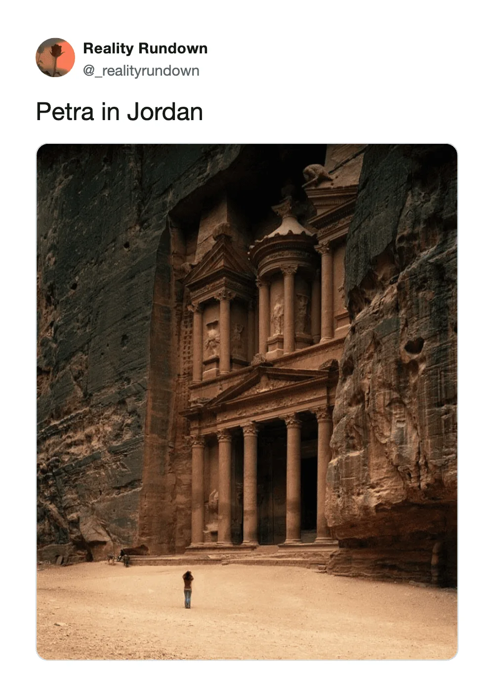 Petra in Jordan with a person standing in front of the ancient rock-cut architecture.