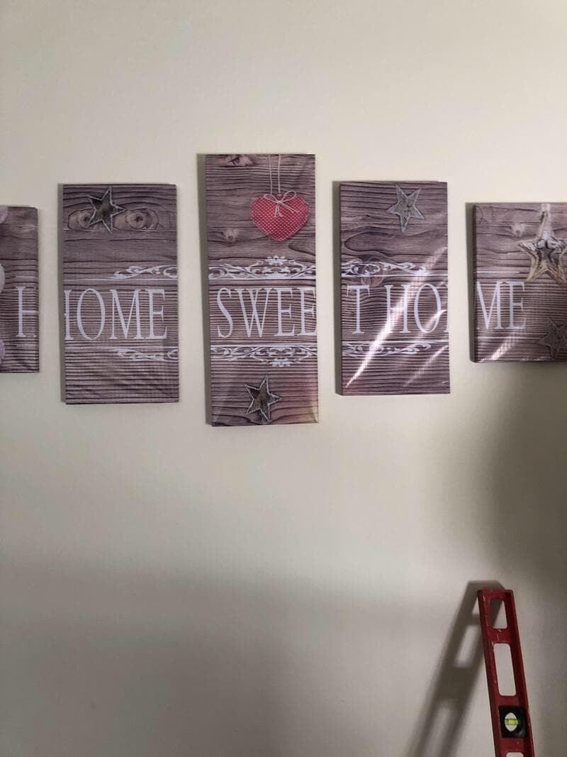 Wooden sign with the words 'HOME SWEET HOME' and decorative stars and heart.