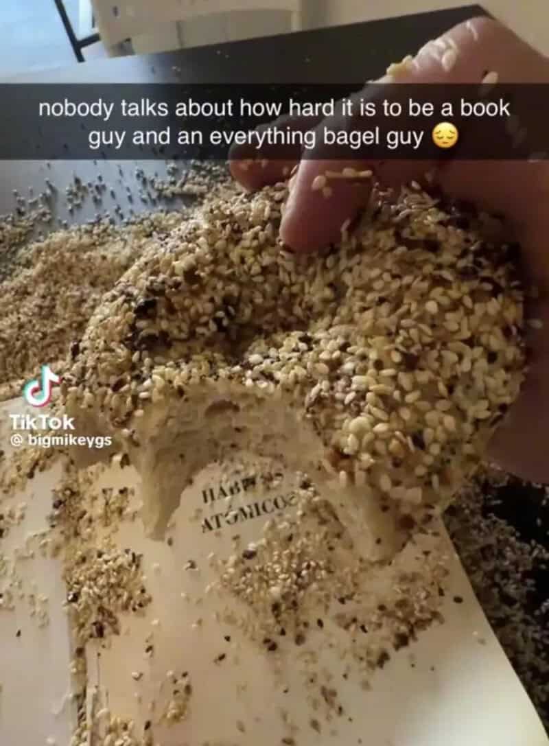 Person holding a bagel covered in sesame seeds with text overlay about being a book and bagel guy.