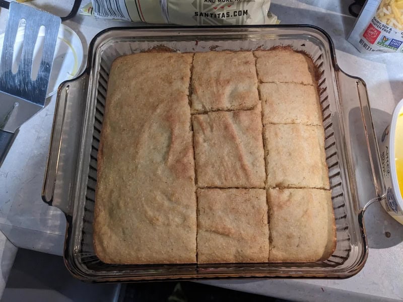 Baked cornbread in a glass dish, cut into squares.