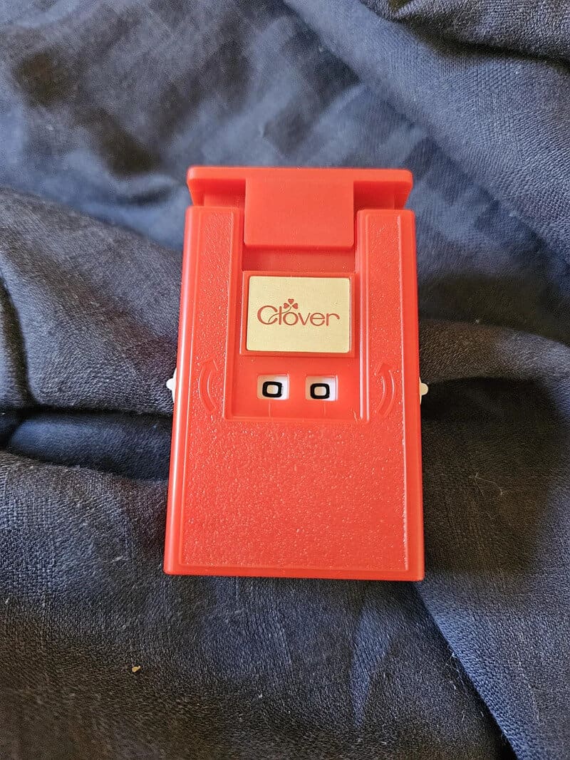 Red Clover calculator with two small windows and a beige logo.